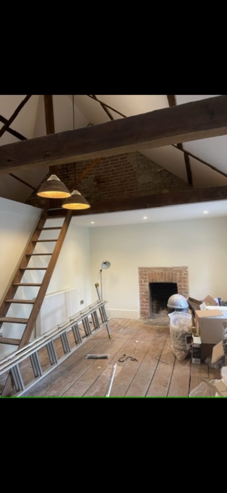 Barn conversion with exposed beams and pendant lights by DS Electrical