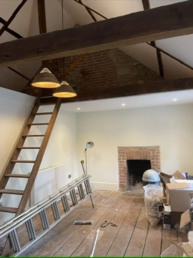 Barn conversion interior lighting between oak trusses