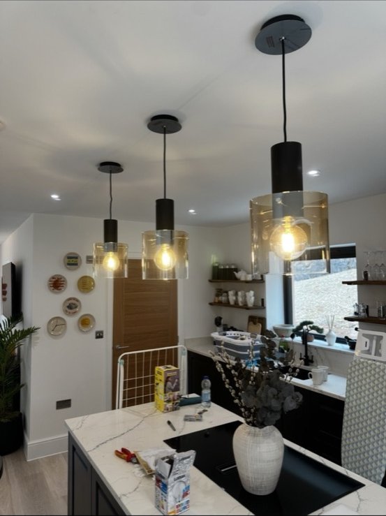 Modern kitchen with black glass pendant lights by DS Electrical