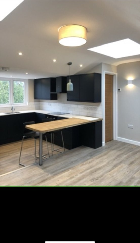 Modern black kitchen with flush ceiling light and skylights